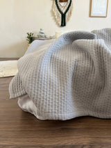 Бавовняне покривало на ліжку сіре